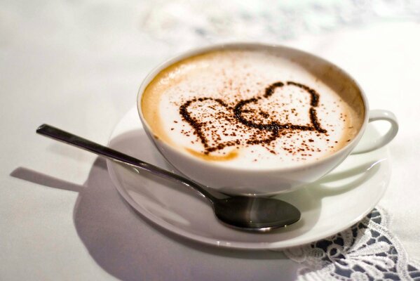 Caffè con cuore in tazza bianca sul tavolo