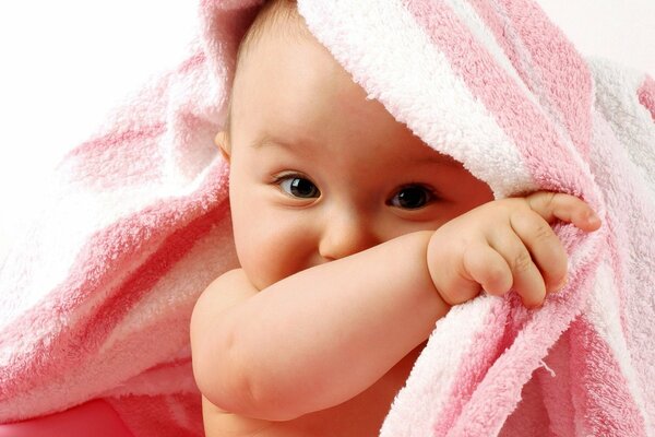 Cute baby in a baby pink blanket