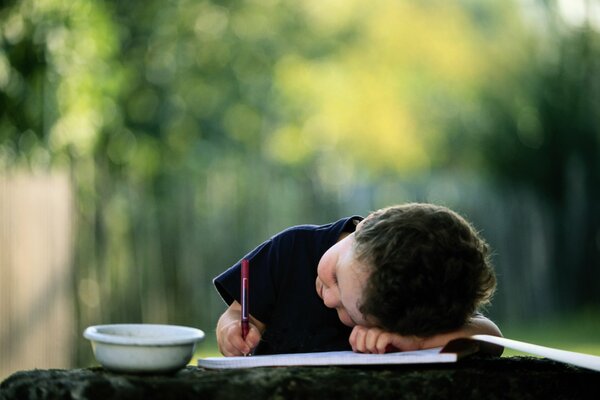 Il bambino scrive con una matita sdraiata