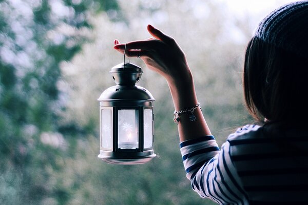 Una lanterna nelle mani di una ragazza illumina la strada per il buon umore