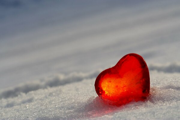 A small red glass heart on white snow