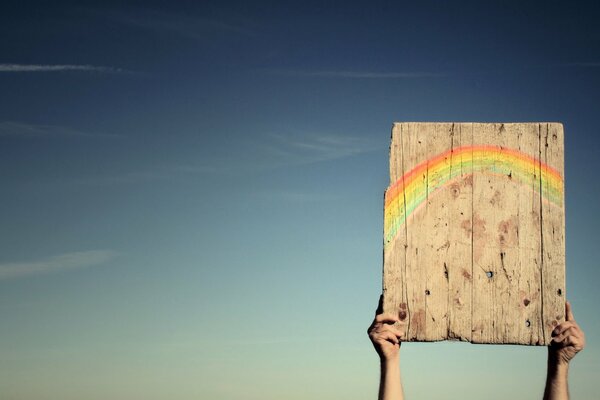 Positivo. Arco iris en el cielo. Felicidad con sus manos