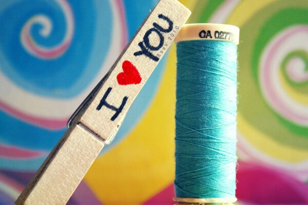 Kolorowe nici i spinacz do bielizny z napisem Kocham Cię