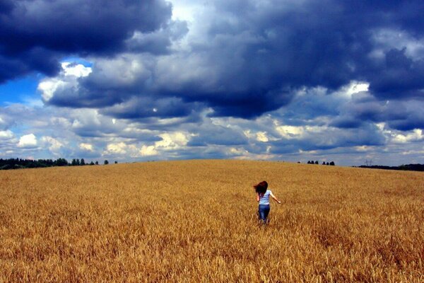 Ragazza che corre attraverso il campo al tramonto