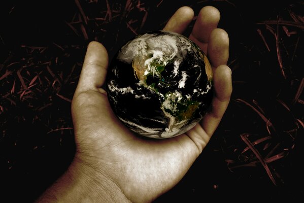 Планета земля маленького размера лежит в человеческой руке