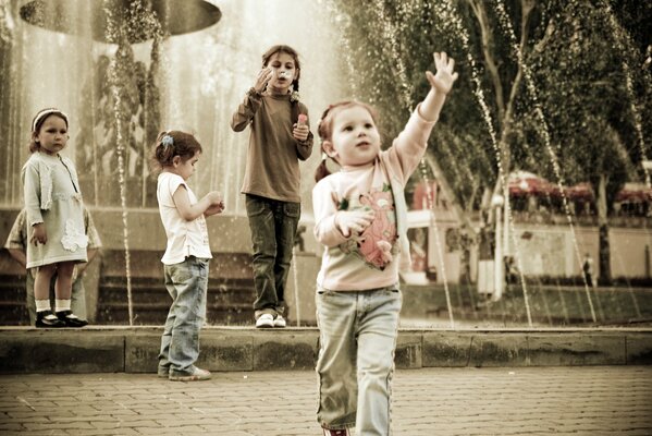 Petits enfants se promènent dans le parc près de la fontaine