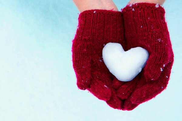 Сердце из снега в руках человека