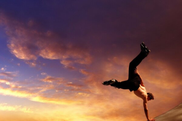 Uomo che balla sullo sfondo del cielo al tramonto