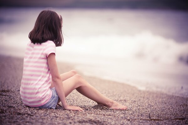 Mädchen sitzt am Meer