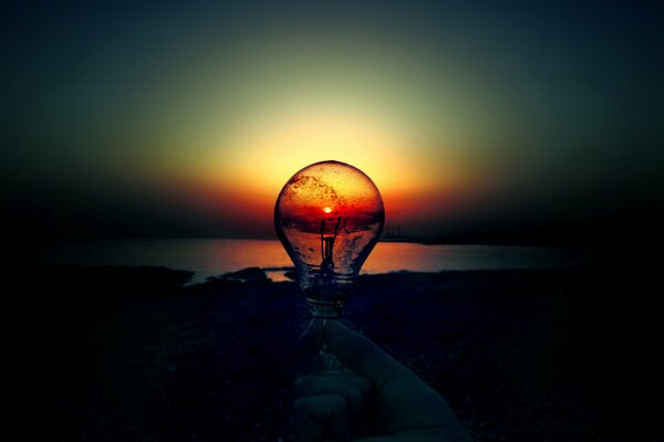 A light bulb in the dark against the setting sun