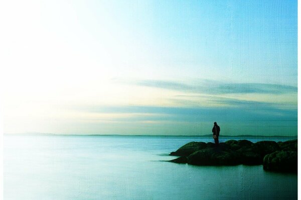 Uomo solitario in piedi in riva al mare