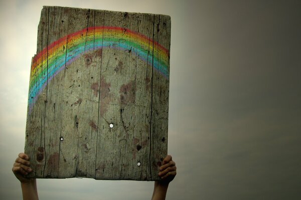 Imagen de un arco iris en una pizarra contra un cielo gris opaco