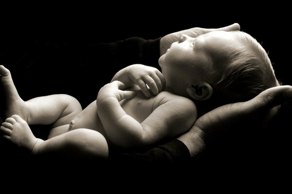 Черно-белое изображение малыша в руках