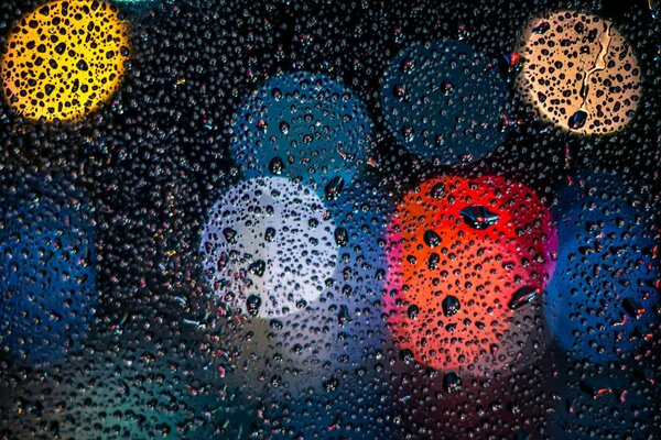 Colored spots on the glass with wet drops