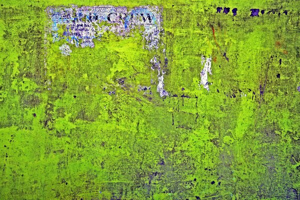 A green wall with a torn, worn poster