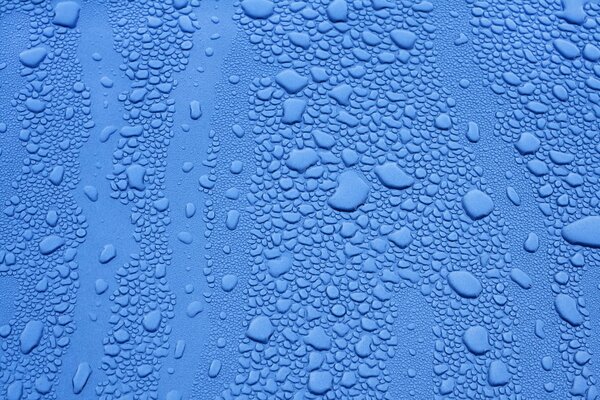 Drops of different sizes on a blue surface