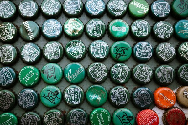 Green tin beer lids lie in even rows