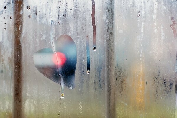 Tropfen auf einem schwitzenden Fenster. Zeichnung auf dem Fenster