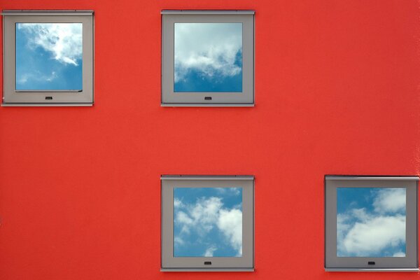 Piccole finestre quadrate sul muro rosso