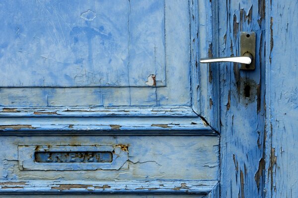 The old door is blue with cracked paint