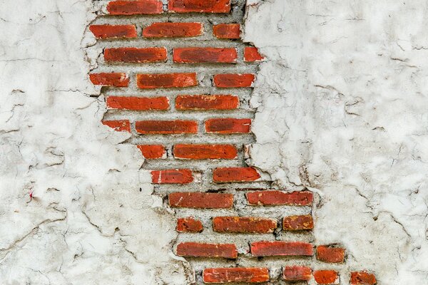 Mur de briques rouges avec plâtre blanc