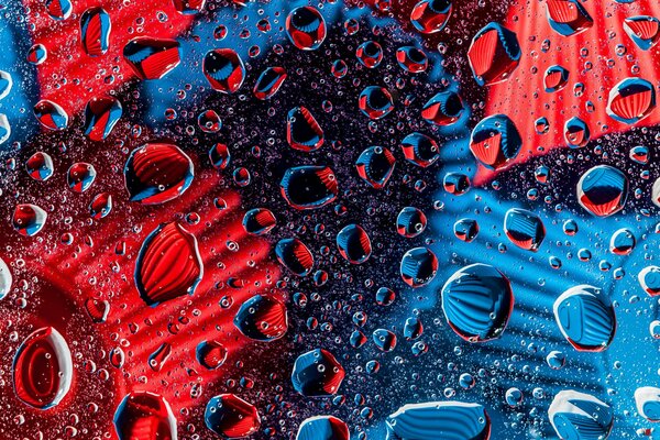 Gouttes rouges et bleues sur le verre