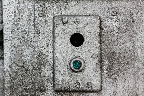 An old gray wall with a blue button