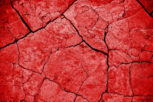 Red texture on the background of cracks of the earth