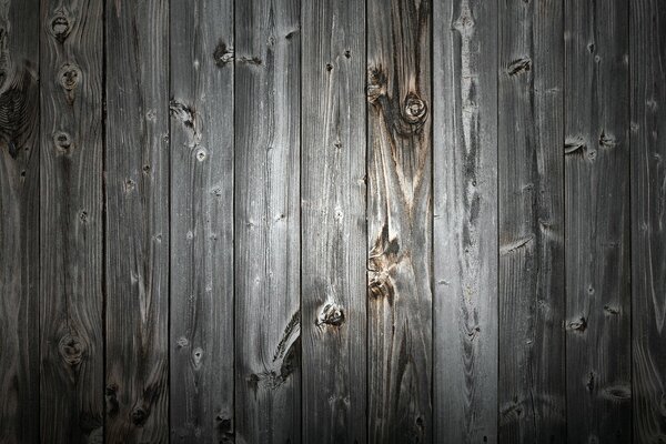 Wood. The wall is made of wood. Grey color