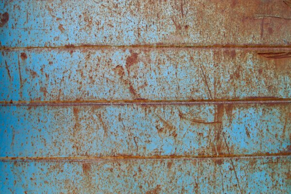 Imagen de una pared de metal azul oxidada y vieja