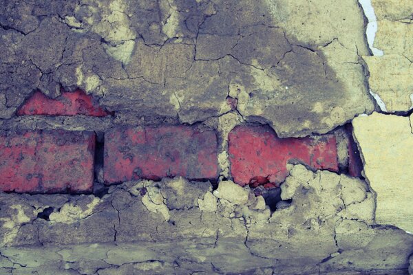 Imagen de una vieja pared de ladrillo naranja y yeso caído