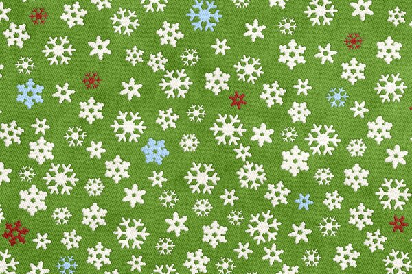 Auf grünem Hintergrund sind Weihnachtsflocken bunt