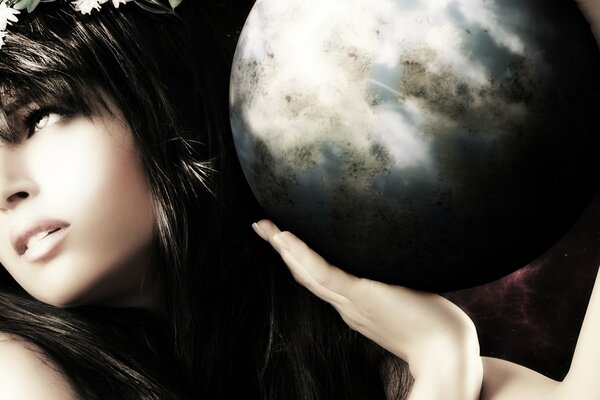 A girl holds a ball of earth in her hands