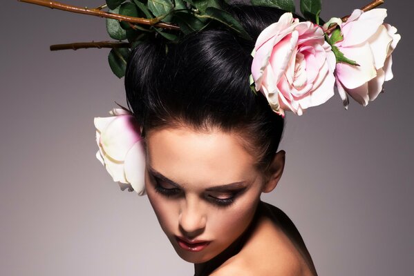 A girl with a hairstyle in which 3 pink roses are displayed