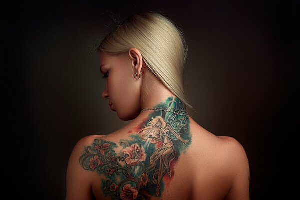 Fille avec tatouage coloré sur le dos