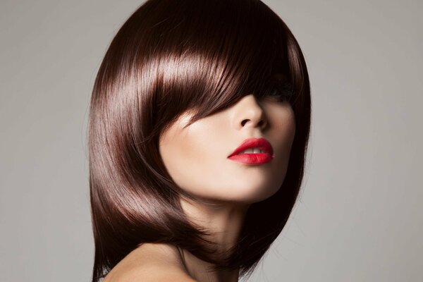 Fille avec coupe de cheveux et maquillage sur fond neutre