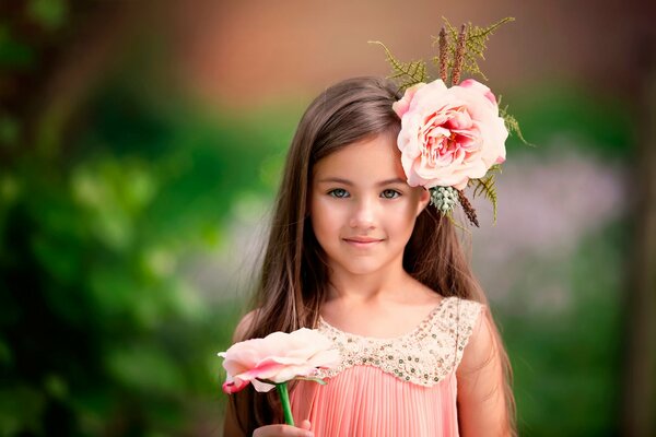 Hermosa chica con una flor rosa en el pelo