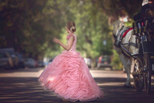 A girl in a lush pink dress on the street
