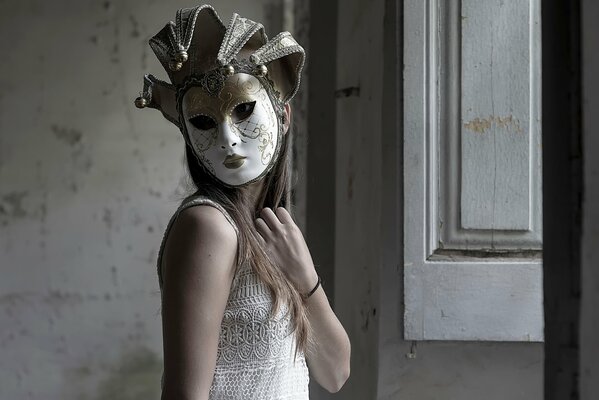 Fille dans un masque de stuc à côté de la fenêtre