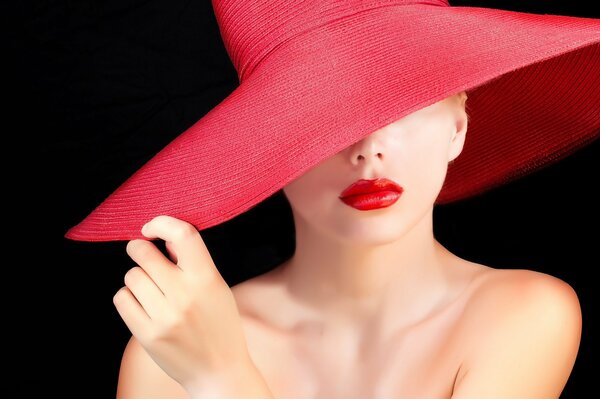 Hermosa chica con sombrero rojo lápiz labial rojo en los labios