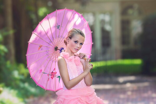A girl in a pink dress and with an umbrella