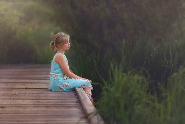 Adorable niña pensativa en el puente