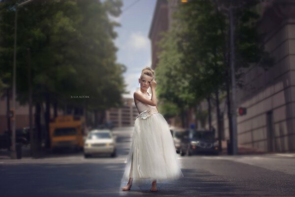 Ragazza in abito bianco sulla strada della città