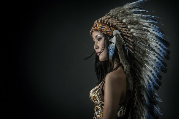 A girl in an apachrle Indian costume, gorgeous feathers