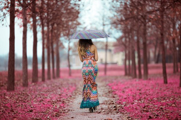 Chica con paraguas caminando por el camino