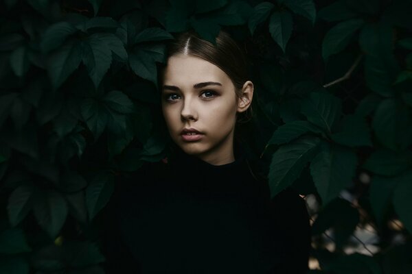 Ragazza sulla foto del ritratto accanto alle foglie