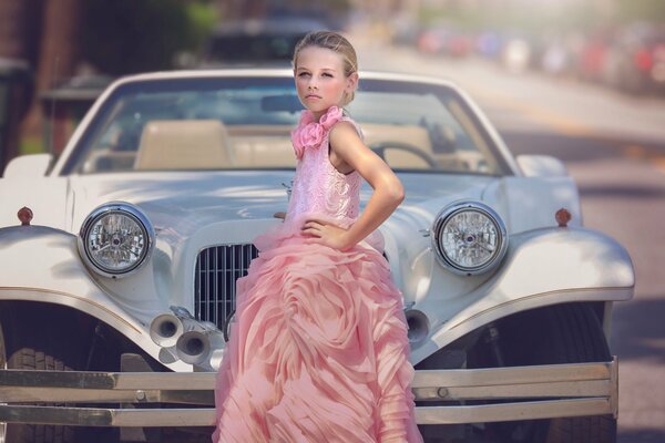 A girl in a pink dress. Retro car