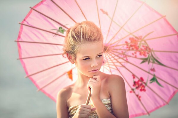 Fille avec un parapluie rose souriant