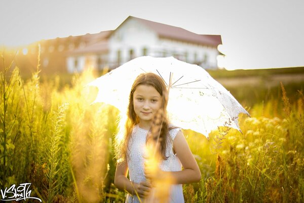 A girl in a field with an umbrella