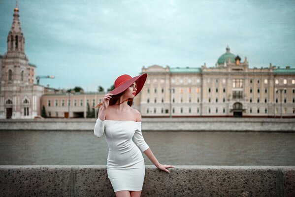 A girl in a white dress. the girl in the red hat. river. embankment